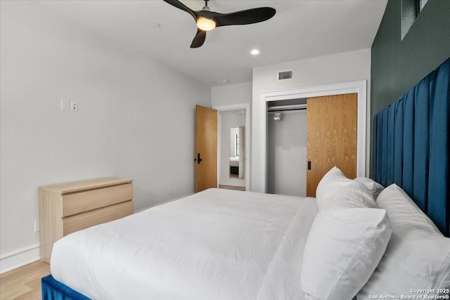 bedroom with ceiling fan, hardwood / wood-style floors, and a closet