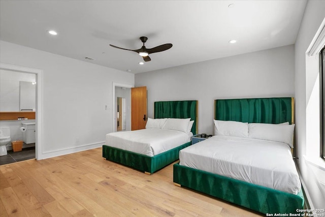 bedroom featuring ceiling fan, ensuite bathroom, and hardwood / wood-style floors