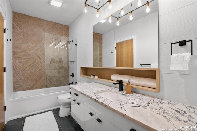 full bathroom featuring tile walls, tiled shower / bath combo, vanity, toilet, and tile patterned floors