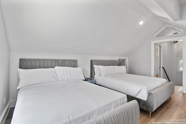 bedroom featuring lofted ceiling and light hardwood / wood-style floors