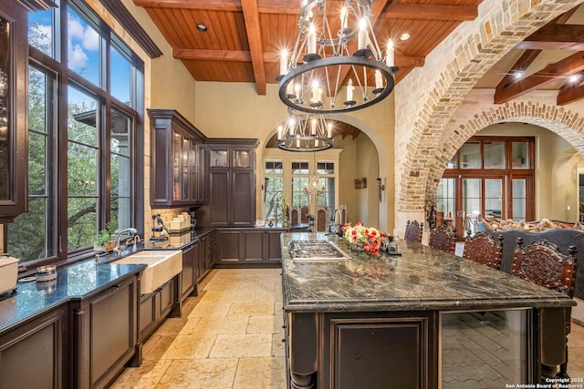 kitchen with wooden ceiling, sink, dark brown cabinets, and a notable chandelier