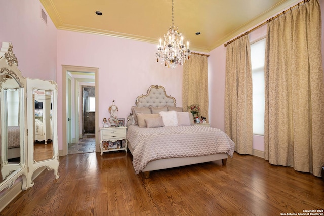 bedroom featuring hardwood / wood-style floors, ornamental molding, and a chandelier