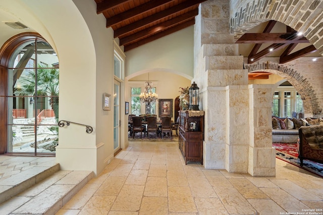 interior space with beamed ceiling, high vaulted ceiling, wood ceiling, and an inviting chandelier