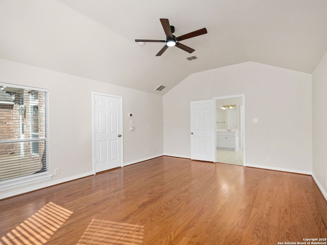 empty room with vaulted ceiling, hardwood / wood-style floors, and ceiling fan