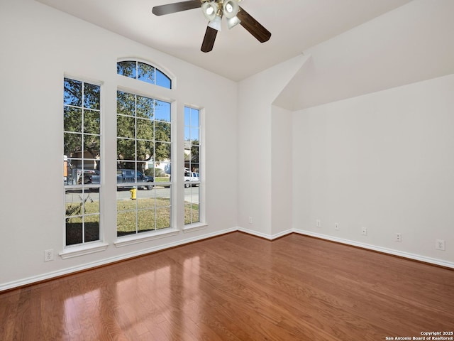 empty room featuring hardwood / wood-style flooring, a healthy amount of sunlight, and ceiling fan