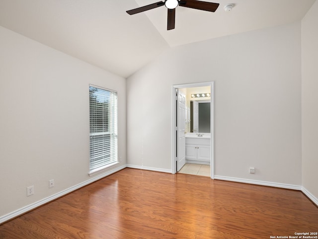 spare room featuring vaulted ceiling, light hardwood / wood-style floors, and ceiling fan