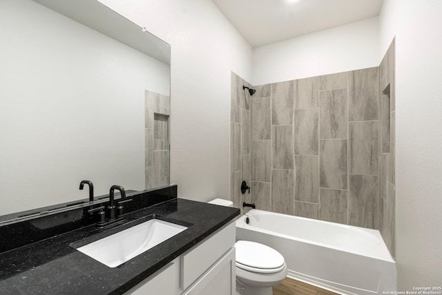 full bathroom with vanity, hardwood / wood-style floors, tiled shower / bath combo, and toilet