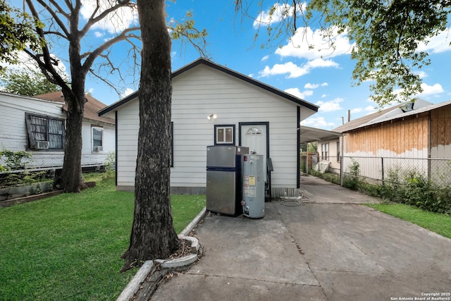 back of property with gas water heater and a lawn