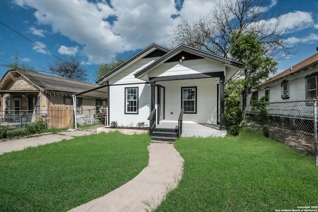 bungalow-style house featuring covered porch and a front yard