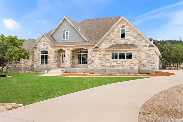 view of front of property with central AC and a front lawn