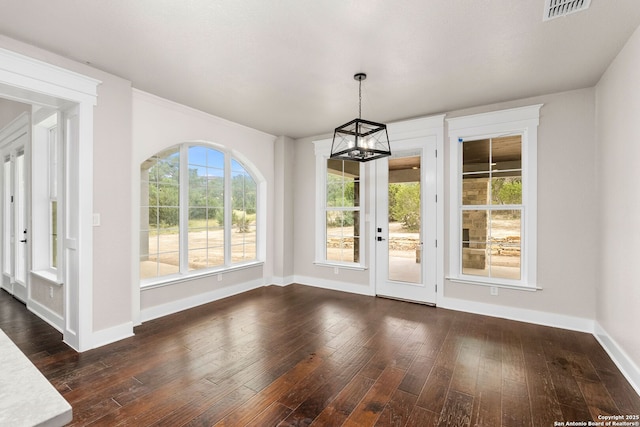 unfurnished dining area featuring dark hardwood / wood-style floors and a chandelier