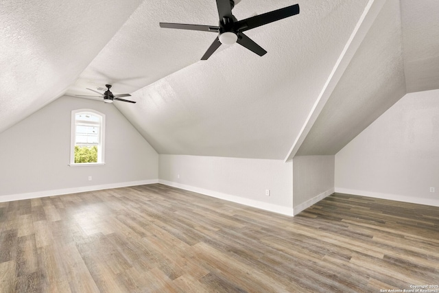 bonus room featuring wood-type flooring, a textured ceiling, and vaulted ceiling