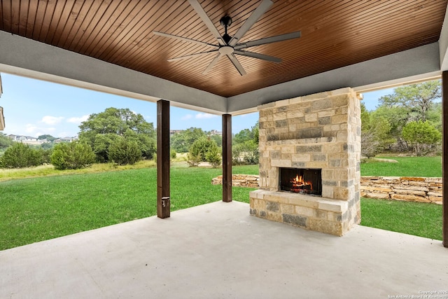 view of patio with ceiling fan and an outdoor stone fireplace