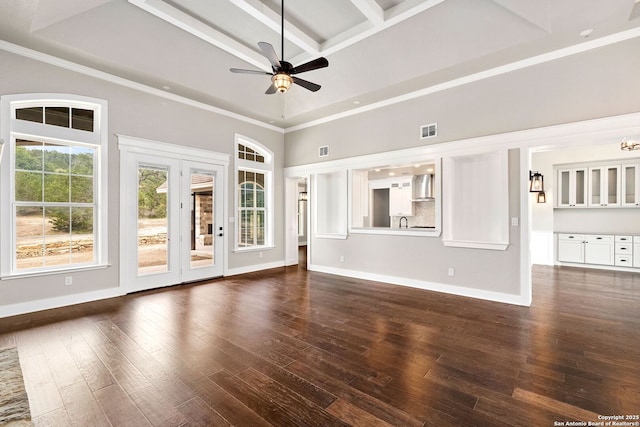 unfurnished living room featuring coffered ceiling, crown molding, dark hardwood / wood-style floors, ceiling fan, and a high ceiling