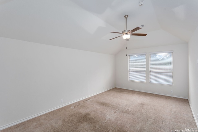 carpeted empty room featuring vaulted ceiling and ceiling fan