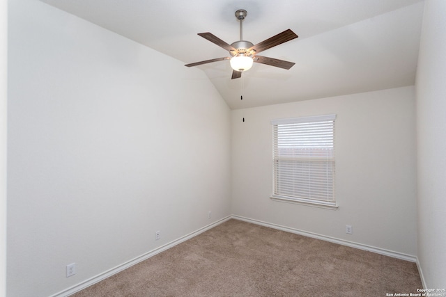 carpeted spare room featuring lofted ceiling and ceiling fan