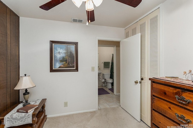 interior space featuring ceiling fan, light colored carpet, and connected bathroom