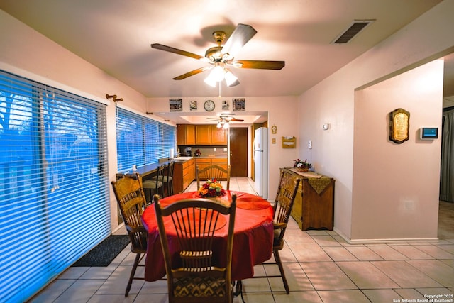 dining space featuring ceiling fan and light tile patterned flooring