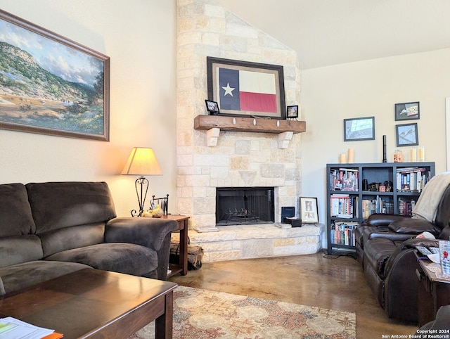 living room with a stone fireplace and concrete floors