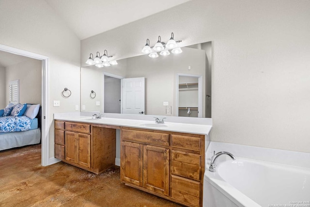 bathroom with vanity, vaulted ceiling, a washtub, and concrete floors