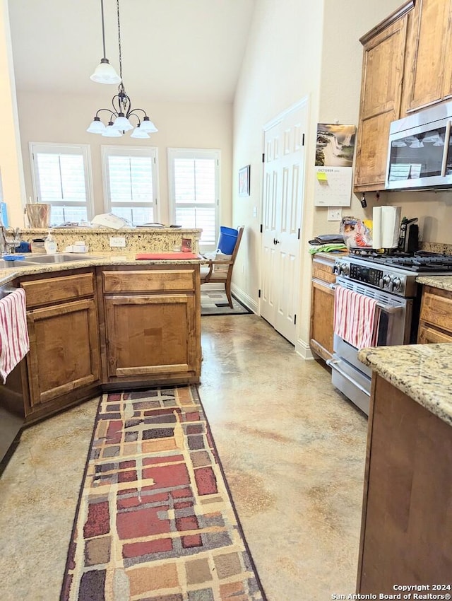 kitchen featuring sink, vaulted ceiling, appliances with stainless steel finishes, a notable chandelier, and pendant lighting