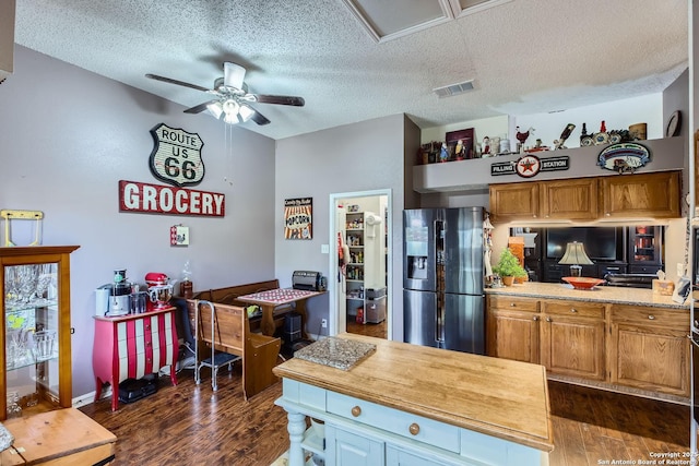 kitchen with a textured ceiling, dark wood-type flooring, ceiling fan, and stainless steel refrigerator with ice dispenser