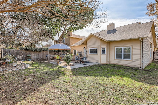 back of property featuring a gazebo, a patio, and a lawn