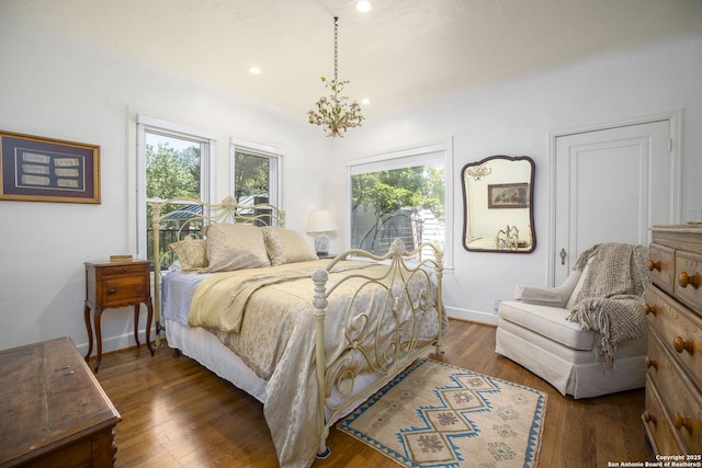 bedroom with dark hardwood / wood-style flooring and a notable chandelier