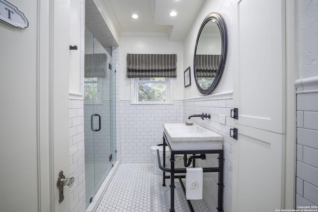 bathroom with sink, tile walls, an enclosed shower, crown molding, and tile patterned floors