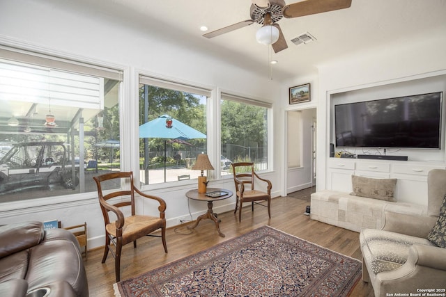 living room with wood-type flooring and ceiling fan