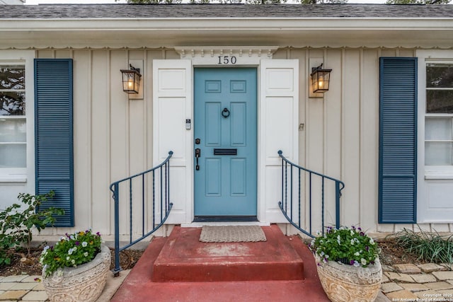 entrance to property featuring roof with shingles and board and batten siding