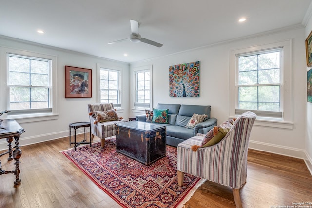 living area featuring a wealth of natural light, baseboards, crown molding, and wood finished floors