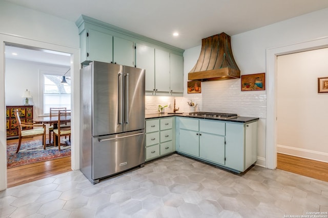 kitchen with recessed lighting, stainless steel appliances, premium range hood, backsplash, and dark countertops