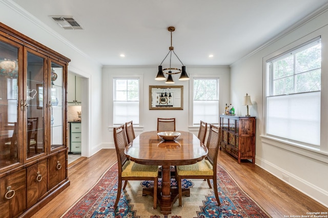 dining room featuring ornamental molding, visible vents, and plenty of natural light