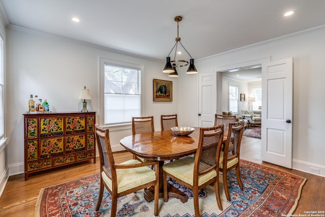 dining space featuring baseboards, ornamental molding, wood finished floors, and recessed lighting