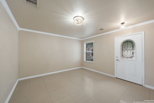 tiled foyer with crown molding and a textured ceiling