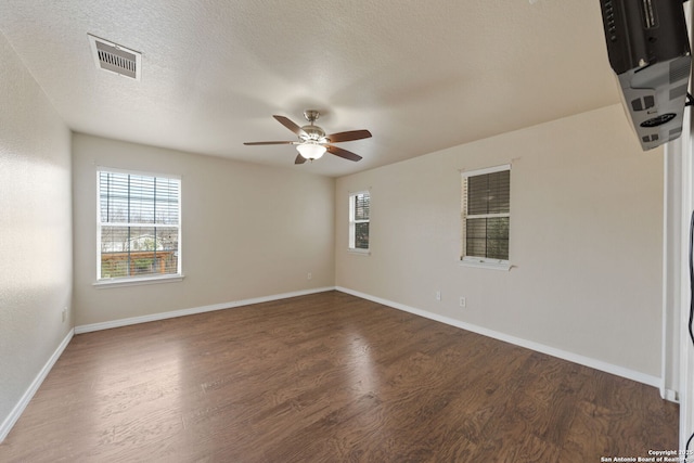 unfurnished room featuring ceiling fan, dark wood-type flooring, and a textured ceiling