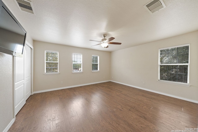 interior space with a textured ceiling, dark hardwood / wood-style floors, and ceiling fan