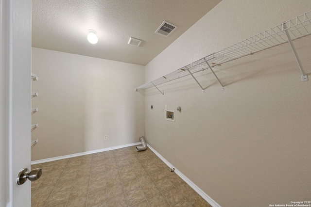 clothes washing area with electric dryer hookup, washer hookup, hookup for a gas dryer, and a textured ceiling