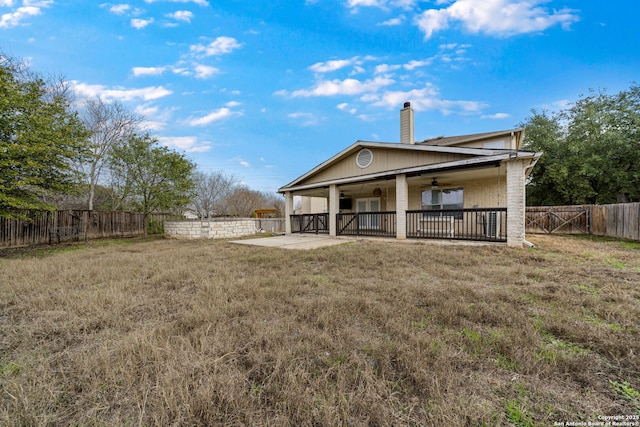 back of house with a patio, ceiling fan, and a lawn