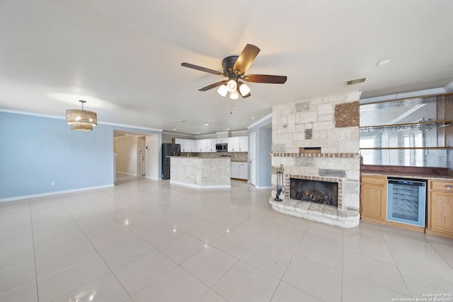 unfurnished living room featuring crown molding, light tile patterned floors, wine cooler, and ceiling fan