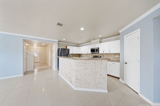 kitchen with ornamental molding, stainless steel appliances, a kitchen island with sink, decorative backsplash, and white cabinets