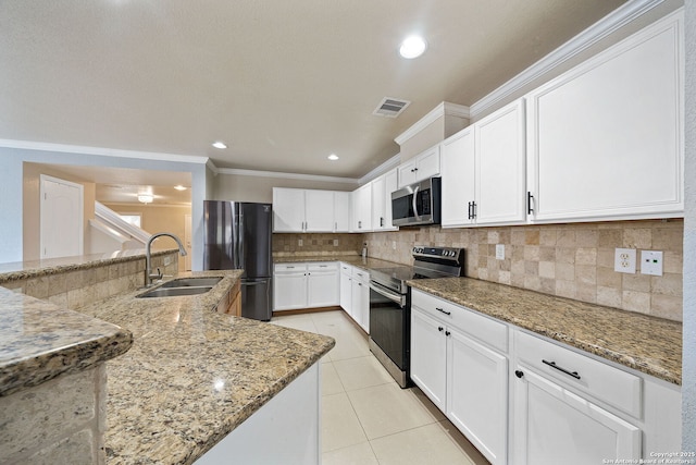 kitchen with white cabinetry, appliances with stainless steel finishes, sink, and light stone counters