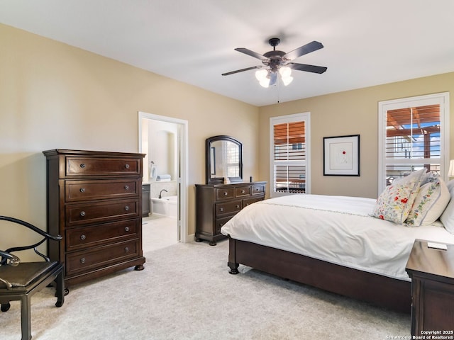 bedroom featuring ceiling fan, ensuite bathroom, and light carpet