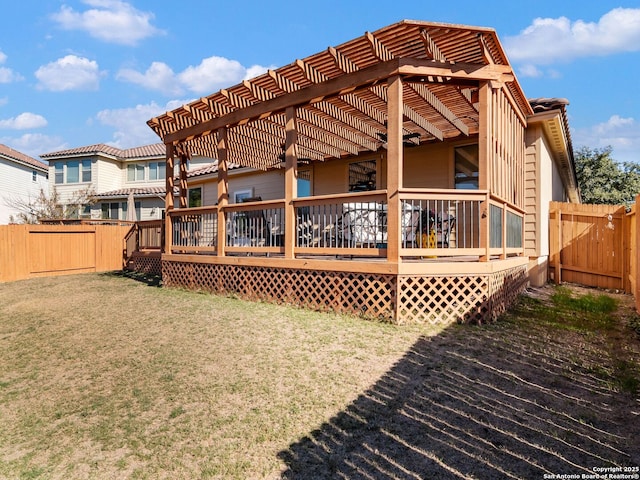 rear view of house featuring a wooden deck and a yard