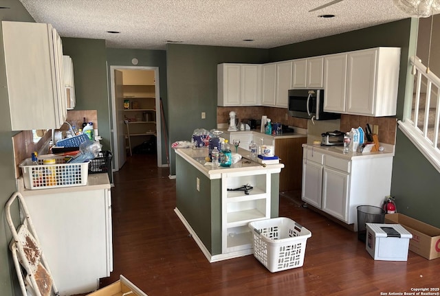 kitchen featuring a kitchen island, white cabinets, dark hardwood / wood-style flooring, and decorative backsplash