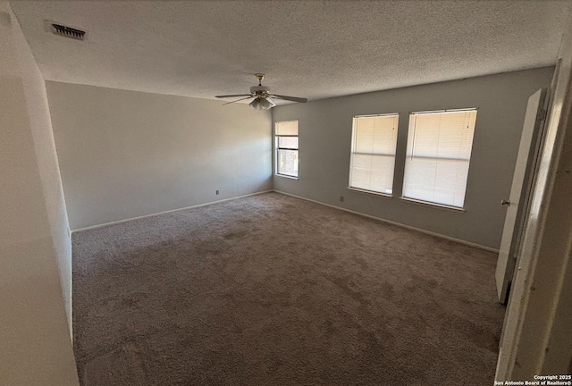 empty room featuring ceiling fan, a textured ceiling, and carpet flooring