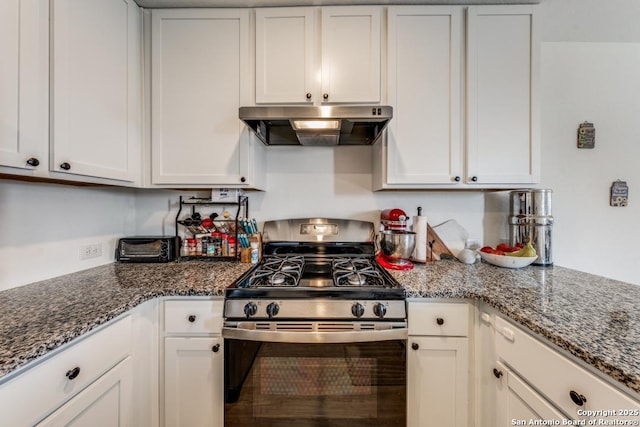 kitchen with white cabinetry, dark stone counters, and stainless steel range with gas stovetop