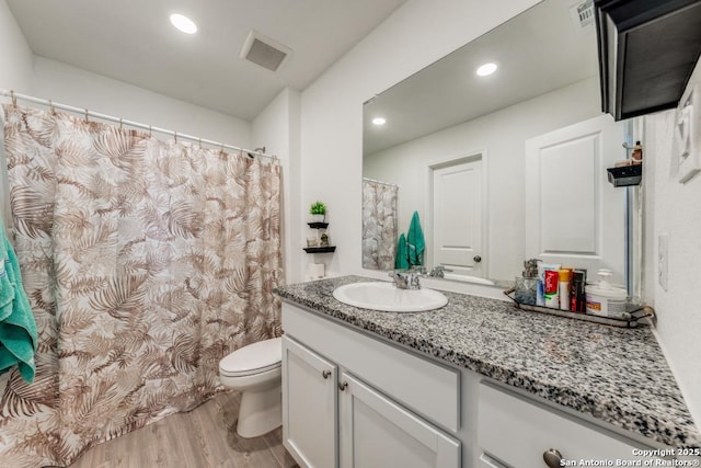 bathroom with vanity, hardwood / wood-style floors, and toilet