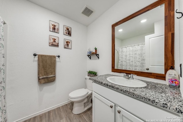 bathroom featuring vanity, hardwood / wood-style floors, and toilet